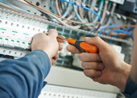 stock-photo-hands-of-electrician-with-screwdriver-tighten-up-switching-electric-actuator-equipment-in-fuse-box-217868863